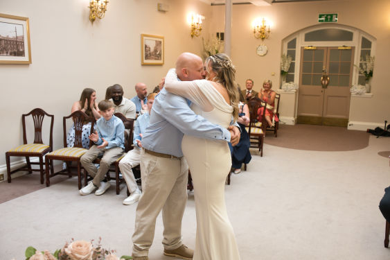 Bride and groom kissing for the fist time in the Sir A Brumwell Thomas room at stockport Town hall 