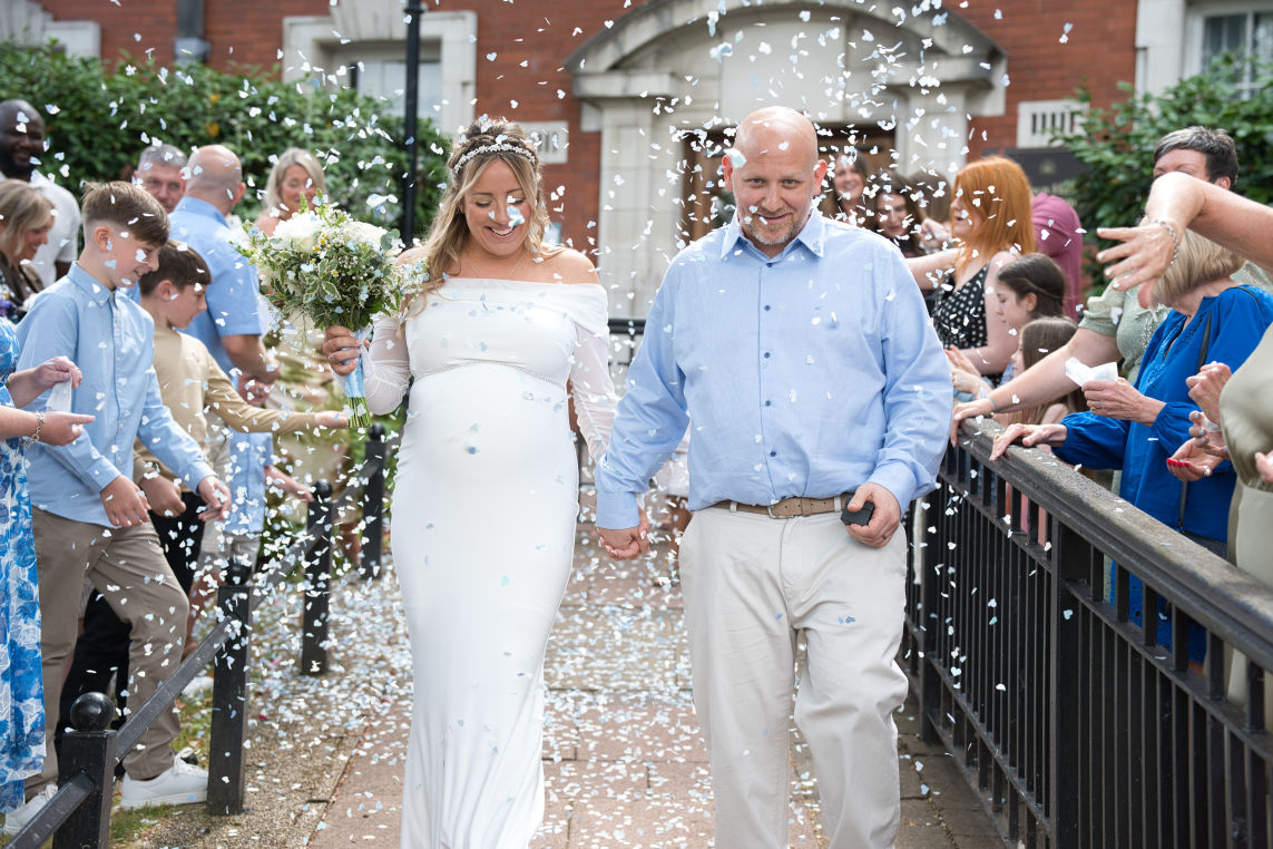 bride and groom just after getting married  getting covered in confetti at stockport townhall