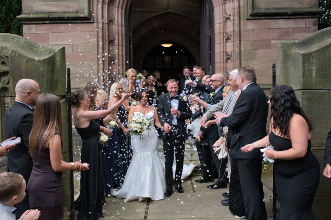 The bride and groom run through the confetti  St George's Church, London Road, Stockport